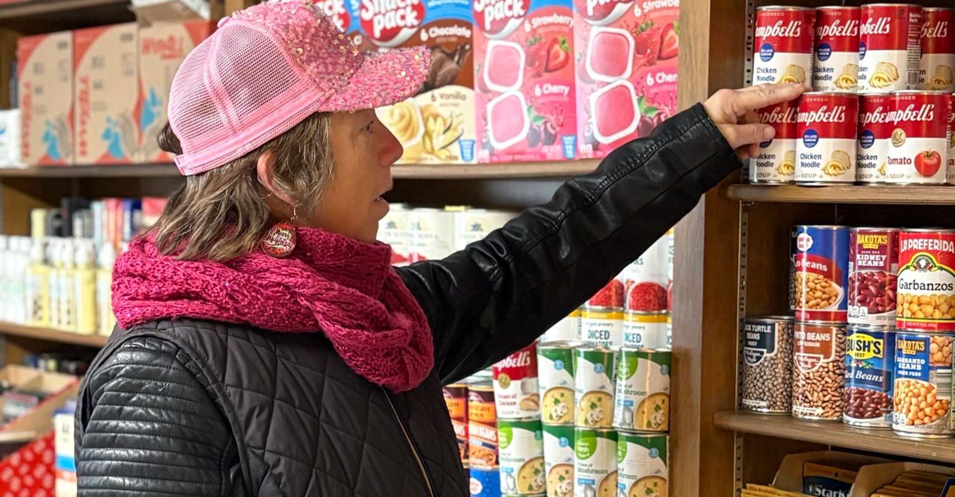 Resident selecting canned food from a Phoenix Family pantry